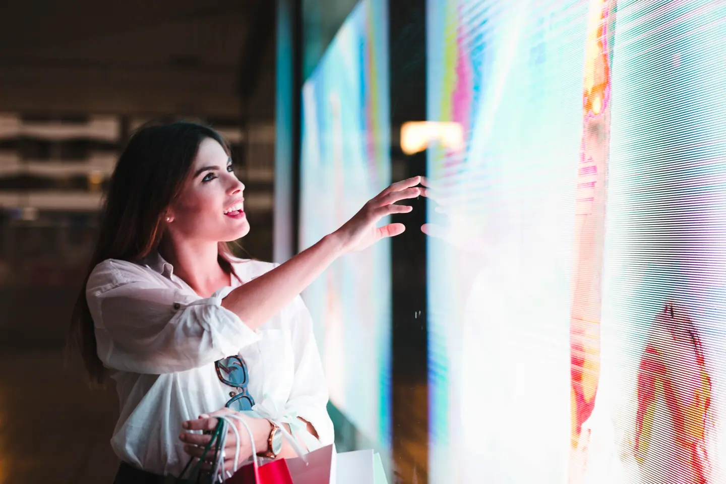 Mujer interactuando con una pantalla LED